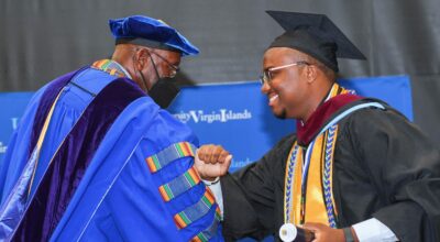 George Francis elbow bumps UVI President Dr. David Hall at Commencement.