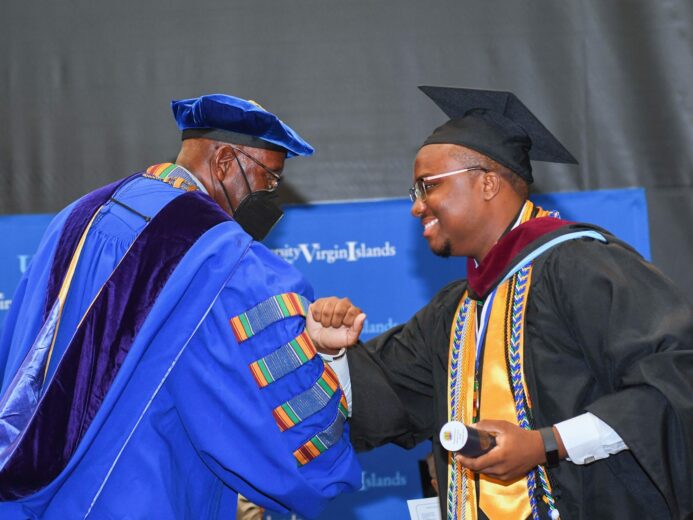 George Francis elbow bumps UVI President Dr. David Hall at Commencement.